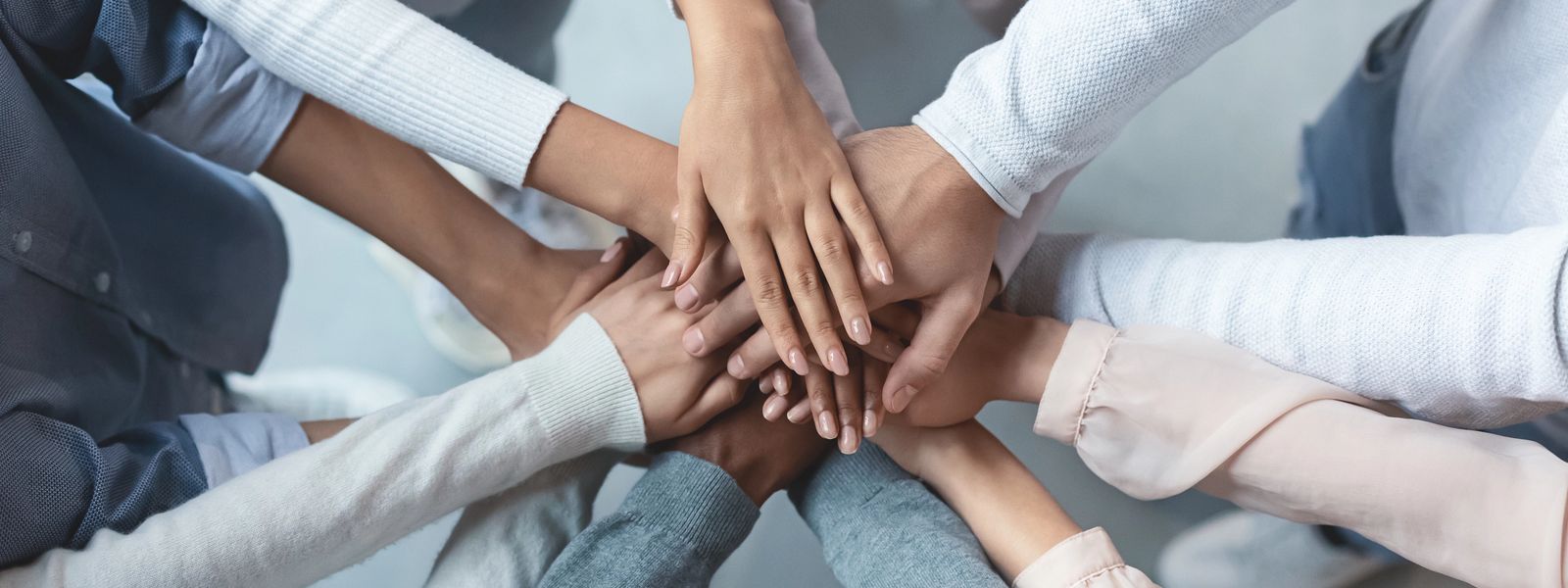 Multiracial business team putting hands on top of each other