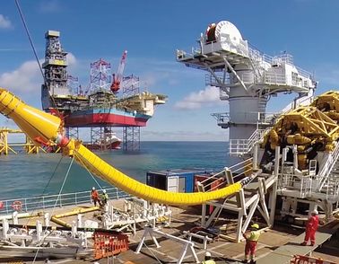 Cable laying vessel NKT Victoria installing an offshore cable with platform Martin Linge in the background